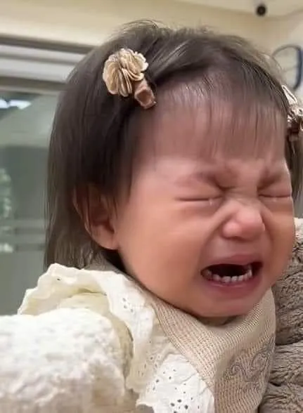 Bé gái khóc thầm, ánh mắt xa xăm đầy u sầu.