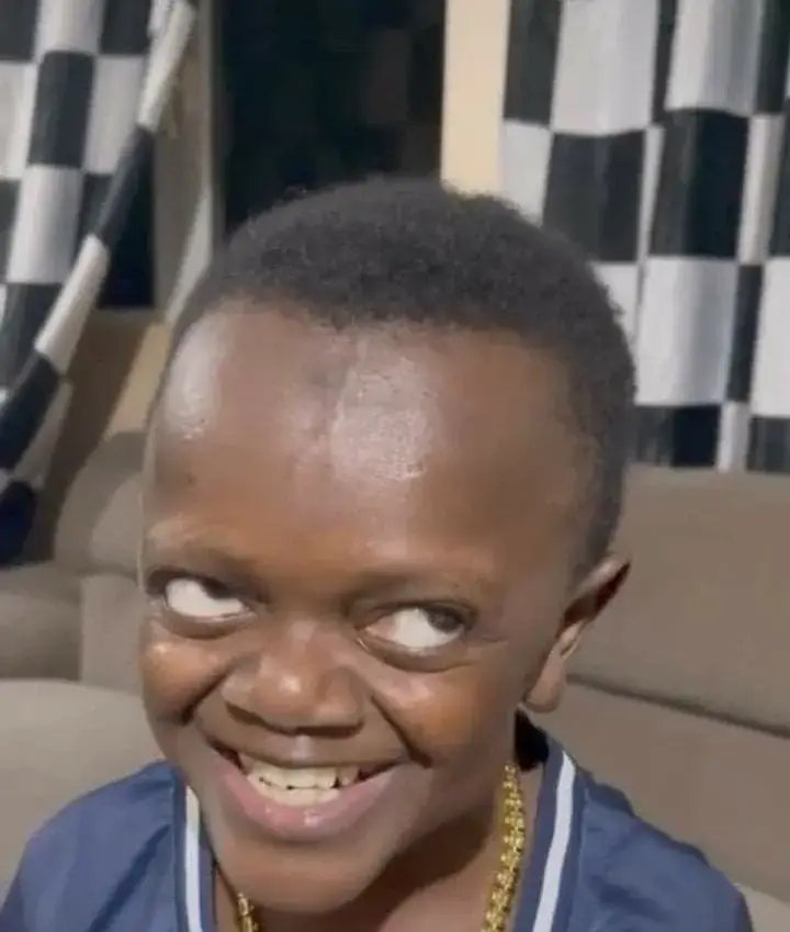 Bé trai da màu bật cười to như thể vừa thắng cược.