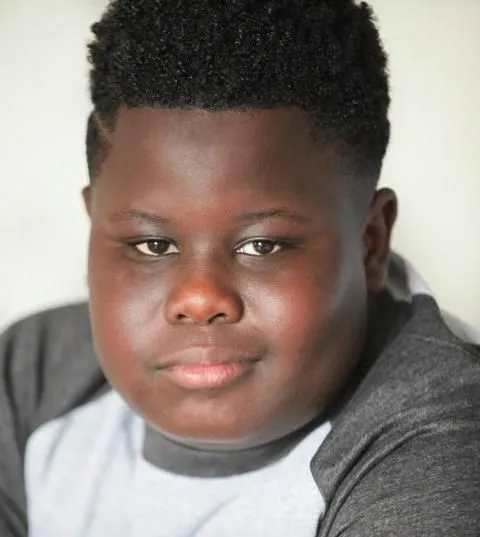 Meme bé trai da đen cười gượng trong buổi họp căng thẳng.