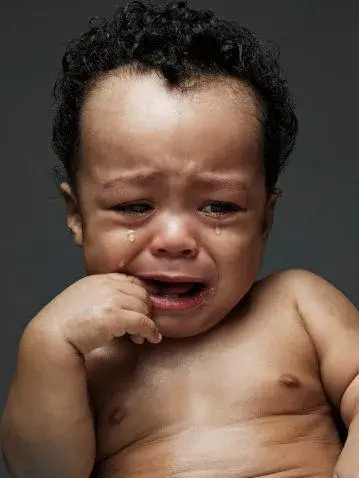 7 Bé trai da đen chống cằm ngồi khóc
