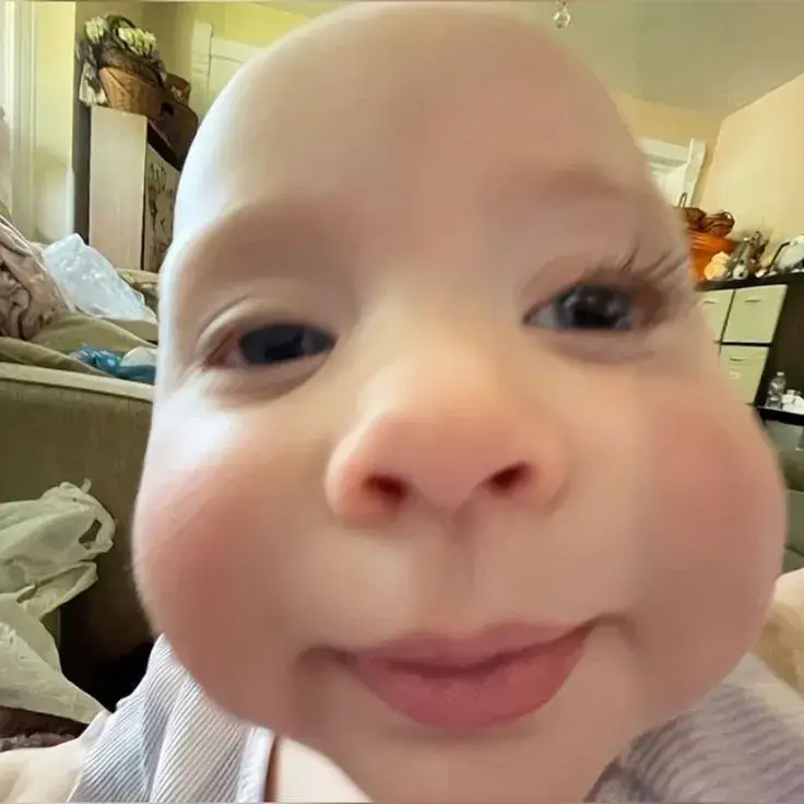 Meme hài em bé cười giữa ánh sáng ấm, nhìn là thấy thương