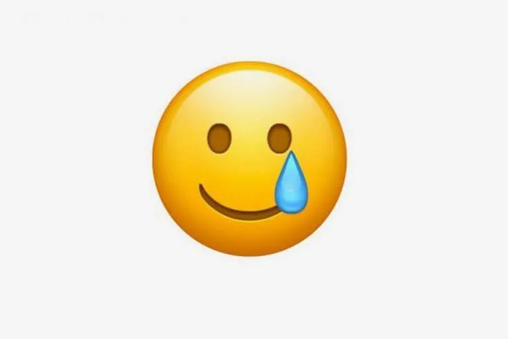 Emoji mặt khóc cười mang tâm trạng xót xa.