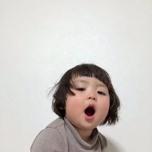 Meme em bé Hàn Quốc với má phúng phính và ánh mắt ngây thơ.