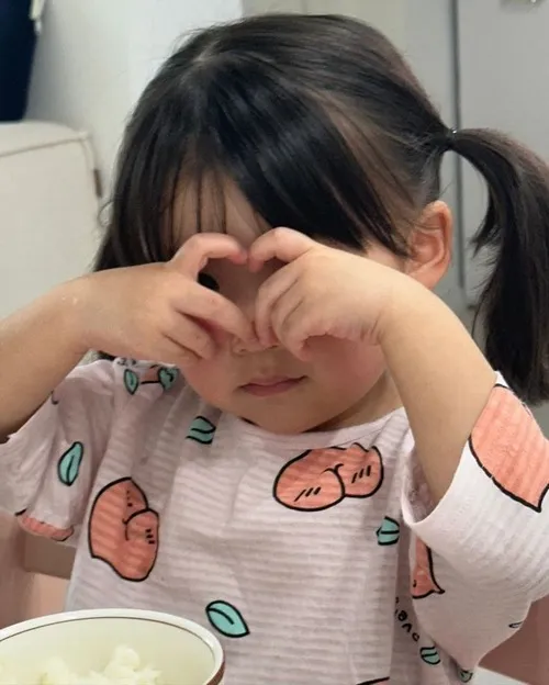 Hình vui bé Hàn chạm tay vào má phúng phính.