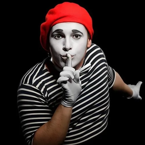 Ảnh vui cử chỉ tay đặt môi, ánh mắt lém lỉnh.